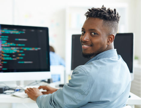 A man sitting at a desk, working on a computer
