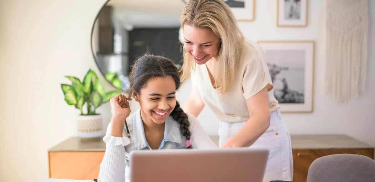 Mother and daughter working togetherwith their laptop